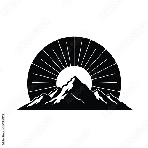 Black silhouette of sun rising over jagged mountains