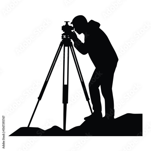 Silhouette of a surveyor using a theodolite on a tripod outdoors