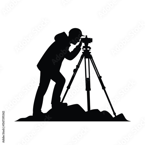 Silhouette of a surveyor using a theodolite on a tripod atop a hill