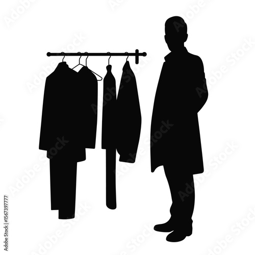 Silhouette of a man standing next to a coat rack with clothes