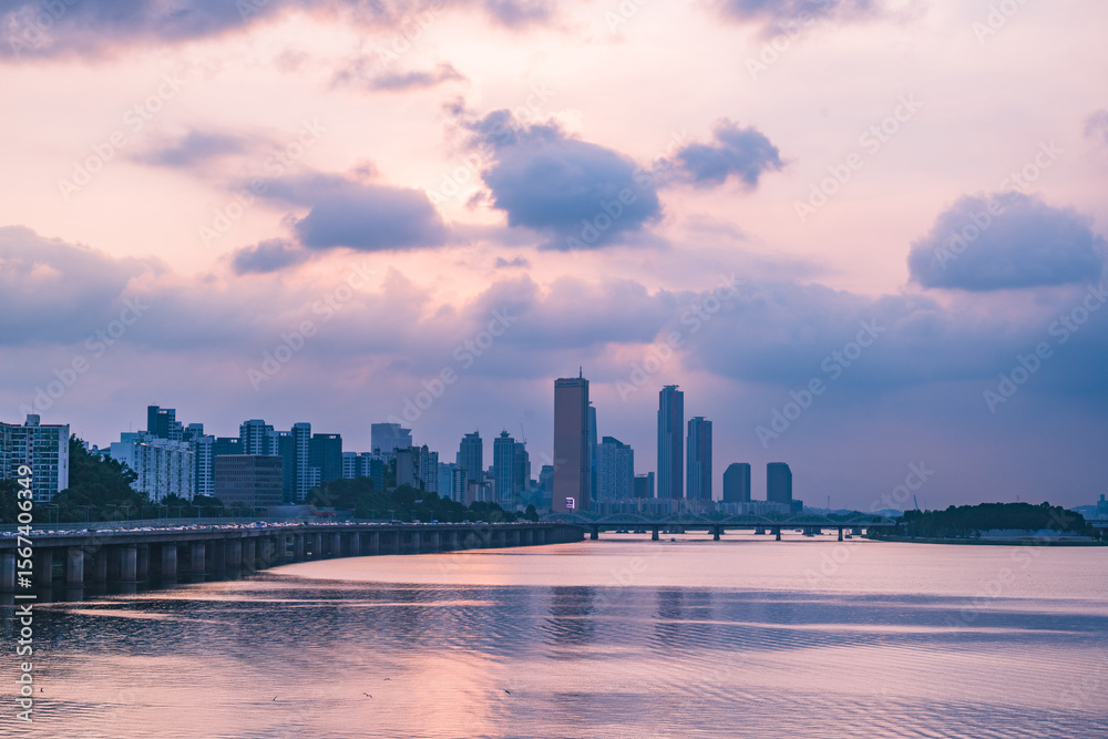 Obraz premium A view of the sunset city of Yeouido in the financial district taken on the Dongjak Bridge on the Han River in summer evening