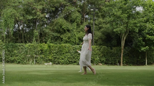 mother and toddler girl playing walk and run circling around on grass field at the park