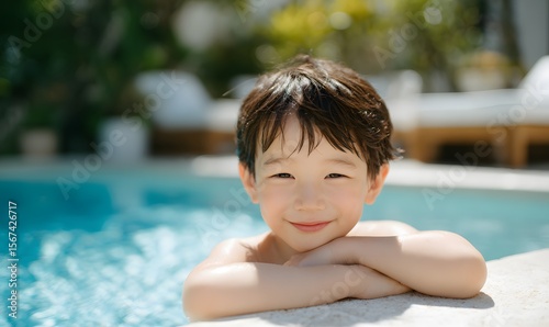 smiling young Korean boy resting his chin on his folded arms by the edge of a clear blue swimming pool,Generative AI