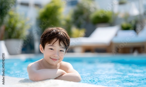 smiling young Korean boy resting his chin on his folded arms by the edge of a clear blue swimming pool,Generative AI