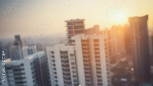 A drone equipped for parcel delivery hovers in the air against a vibrant sunset. Urban buildings create a backdrop as the drone prepares to drop the package, showcasing modern technology