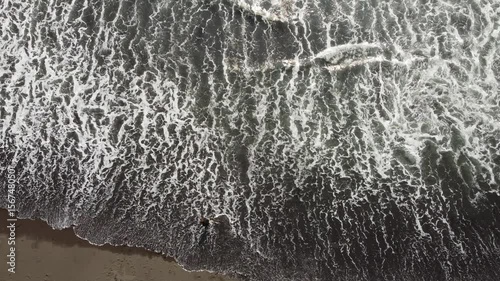 Aerial view of black sand beach and person in water, Kamchatka