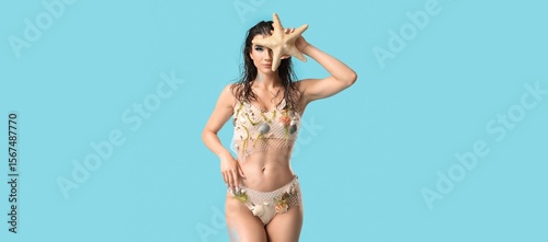 Tableau sur toile Beautiful young woman dressed as siren on light blue background