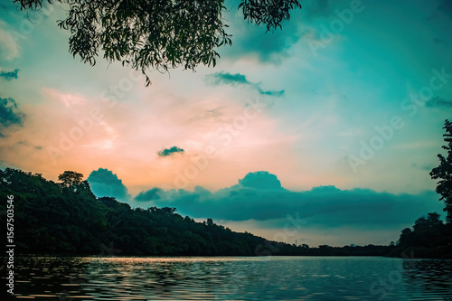 Scenic river landscape at sunset with golden light reflecting on calm water and lush green surroundings. Ideal for nature themes, eco travel visuals, and tranquil outdoor designs