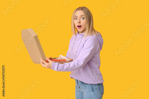 Young shocked woman holding...