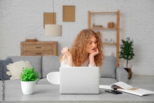 Young woman with laptop wri...
