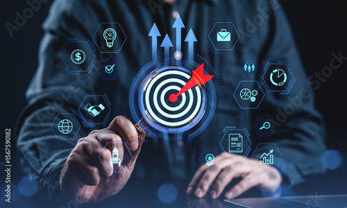 Business success concept with man analyzing target using magnifying glass surrounded by digital icons and strategy symbols on dark background.