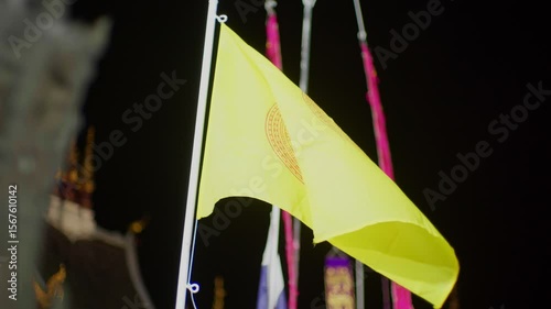 Buddhist Dharma Wheel Flag Waving at Thai Temple at Night