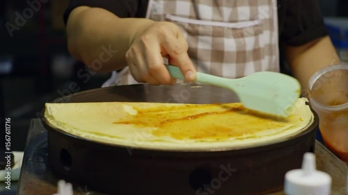 Street Vendor Spreading Sauce on Hot Crepe � Close-Up Cooking Shot