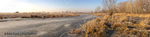 lake in autumn steppe covered with ice at dawn
