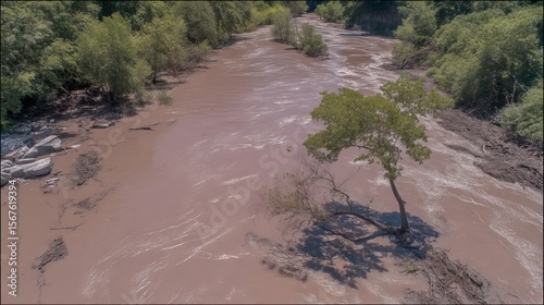 Aerial wide-angle view of flooded landscape with submerged fields and muddy river. Natural disaster captured by drone for emergency or climate stock content