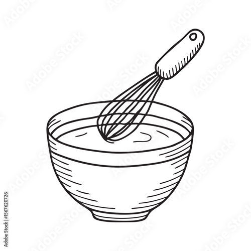 A wire whisk resting across the rim of a mixing bowl
