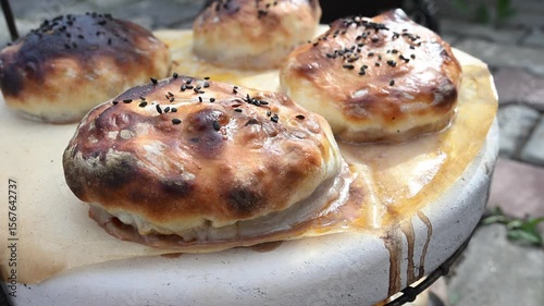 Baked samsa with golden crispy crust cooked in tandoor, traditional Uzbek and Central Asian cuisine, close-up.