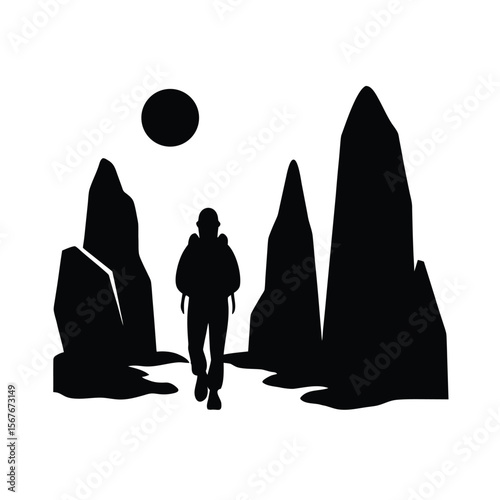 Silhouette of a hiker walking between tall rock formations under a sun