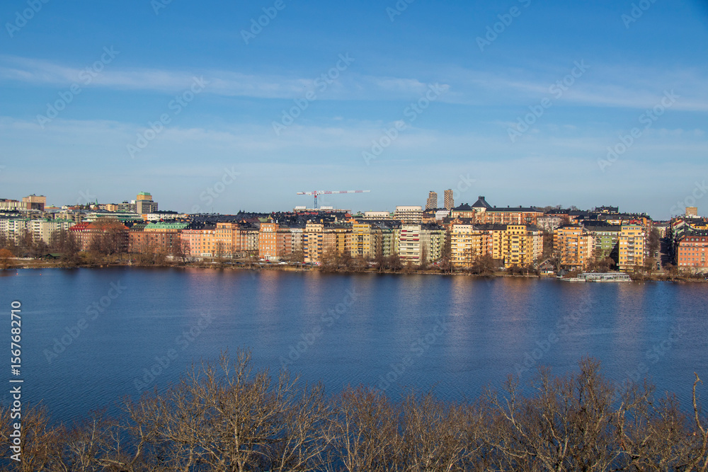 Fototapeta premium Scenic panoramic view of Stockholm city waterfront on a clear sunny day. Panorama of Stockholm architecture along the riverside.