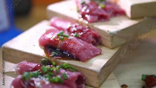 Raw marinated pork slices with sauce and green onions served on wooden trays for BBQ or hotpot cooking