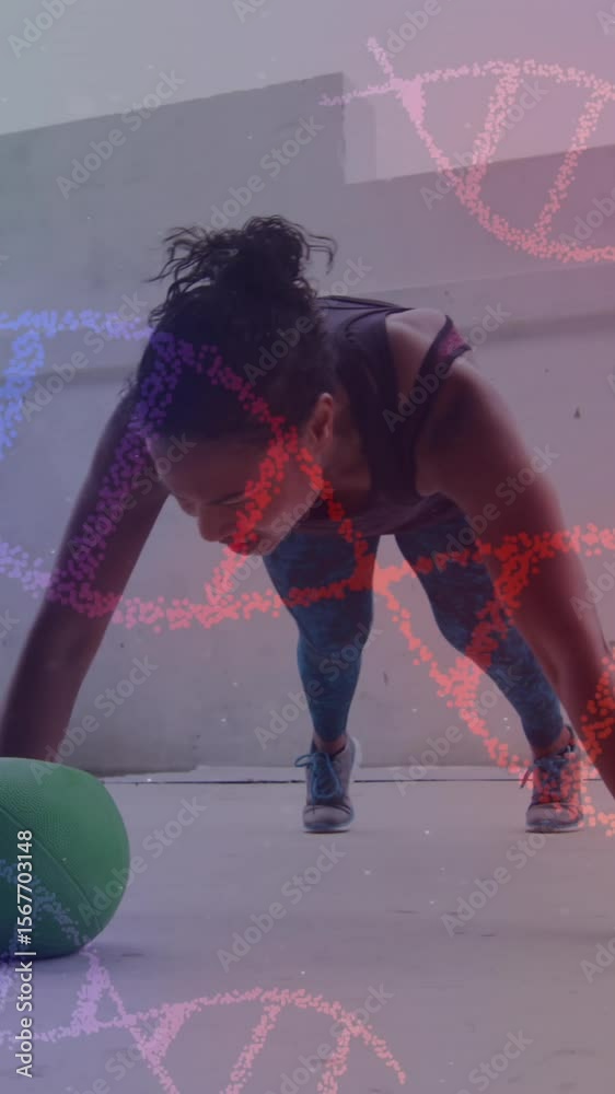 Animation of dna strands spinning over woman doing press ups, exercising with ball in gym