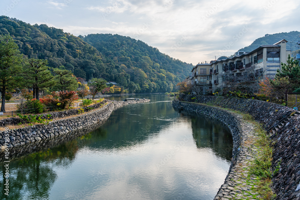 Obraz premium Scenic sight on a sunny autumn morning along the Uji river in Kyoto, Japan.