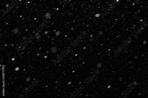 Abstract snowfall texture with blurred snowflakes on dark background for graphic design overlays