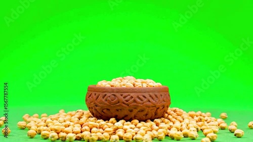 Vibrant Green Background Showcases Decorative Clay Bowl Filled with Yellow Chickpeas, Celebrating Abundance of Natural, Healthy, Organic Food Rich in Nutrition from Grain and Legumes