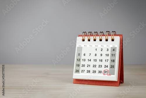 Date 31 is circled in red with the word Retire on small desk calendar. Retirement planning concept, with copy space.