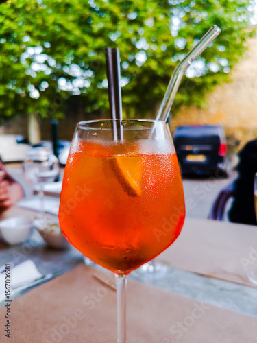 A glass of alcoholic Spritz made from sparkling white wine, accompanied by ice cubes and a slice of orange, and widely consumed as an aperitif throughout Italy.