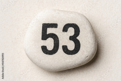 A Numerical Marker Embedded in a White Pebble