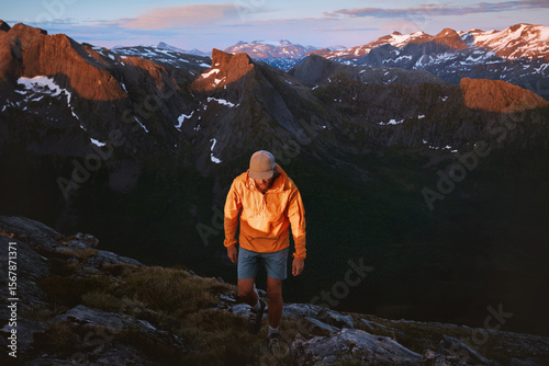 Man hiker traveling in Norway hiking in sunset mountains active adventure trip, traveler climbing healthy lifestyle extreme vacations mountaineering solo