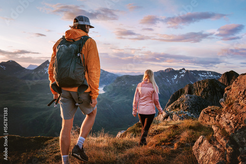 Couple friends hiking in sunset mountains travel in Norway, hikers group man and woman backpacking summer adventure active vacations, healthy lifestyle outdoor trip family trekking journey in the wild