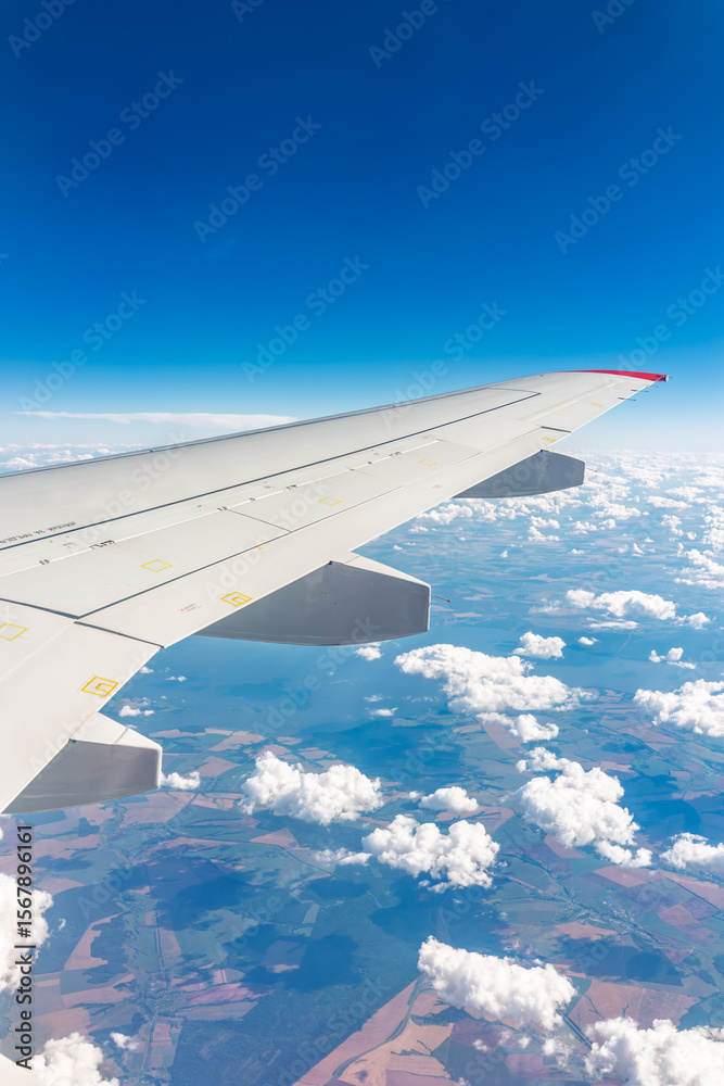 Obraz premium View from the airplane window at a beautiful cloudy sky and the airplane wing