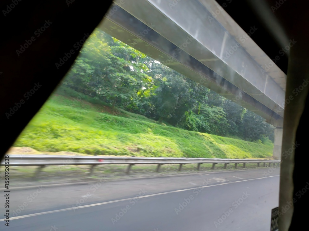 Naklejka premium Highway View from Vehicle with Trees and Guardrail 