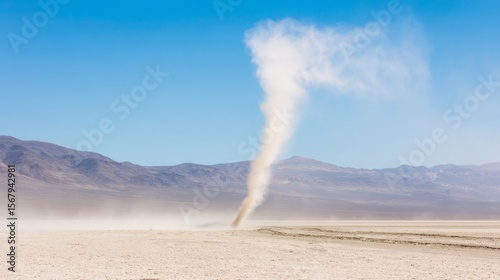 Swirling dust devil in vast desert landscape under clear blue sky, natural phenomenon and weather concept, isolated and dynamic movement.