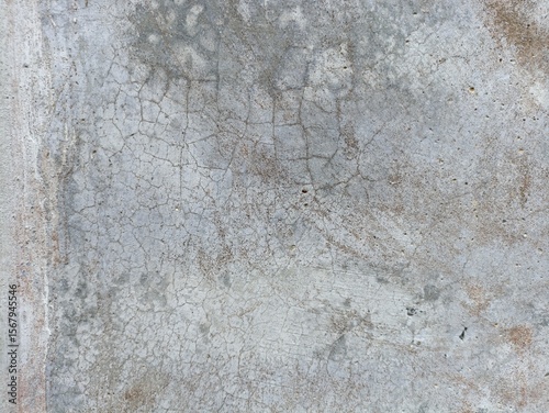 Severely Cracked & Stained Concrete. A close-up of very old, grey concrete with an extensive network of fine cracks and rusty-brown discoloration