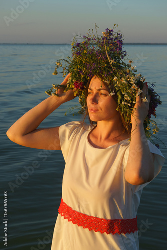 Portrait of a girl in a white dress, Slavic appearance with a wreath of wild flowers on her head