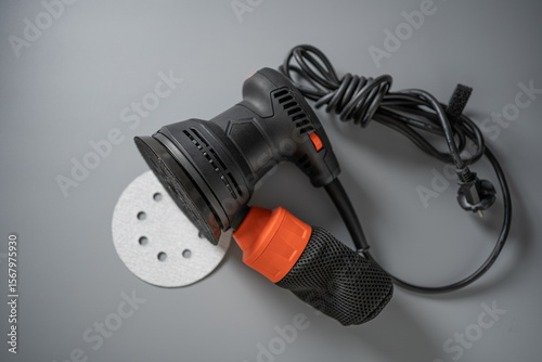 Sanding tool ready for renovation project with ergonomic design and vibrant accents set against a sleek gray backdrop