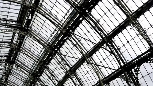 A close up of the intricate glass panels and iron supports of the Crystal Palace, showcasing its Victorian design