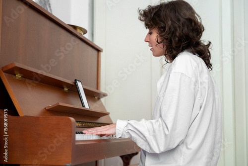 A skilled musician engages deeply with a beautiful piano, creating captivating music in a cozy indoor space