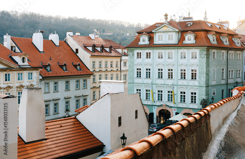 Charming European buildings with red rooftops and ornate facades in morning light.