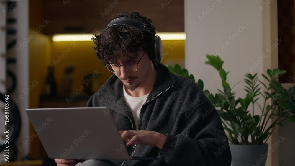 Thoughtful Caucasian guy hipster using laptop computer buying goods online at home male freelancer entrepreneur thinking decide solution man consumer typing pc web user broker programming remote job