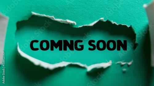 Coming Soon message behind torn green paper