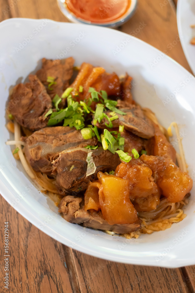 A delicious serving of tender meat with vegetables, garnished with green onions, showcasing vibrant flavors and textures. A delicious serving of tender meat with vegetables, garnished with green onions, showcasing vibrant flavors and textures.