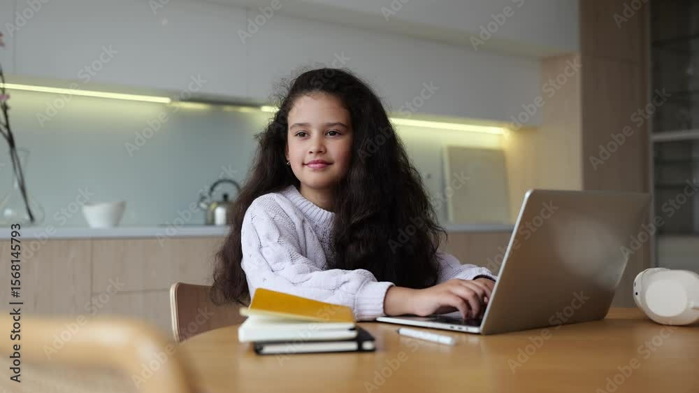 Girl using a laptop at a cozy workspace while enjoying her creative learning session in a bright, modern environment Girl using a laptop at a cozy workspace while enjoying her creative learning session in a bright, modern environment