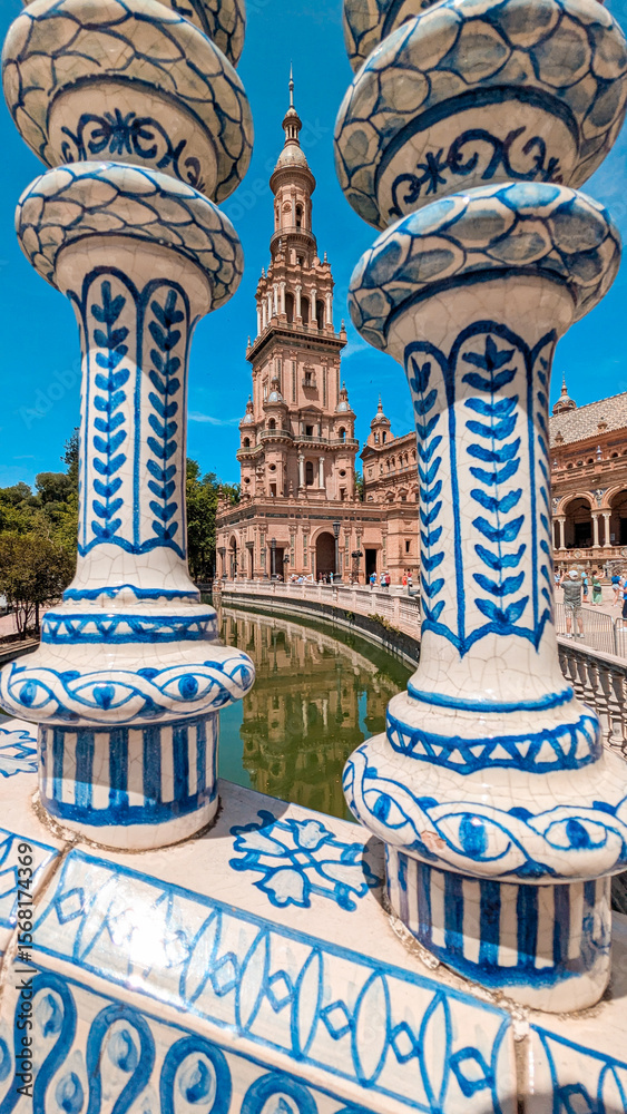 Fototapeta premium Symmetrical composition of decorative ceramics in blue with the tower of the Plaza de España in Seville in the background, one of the most important architectural icons of the Andalusian city. 