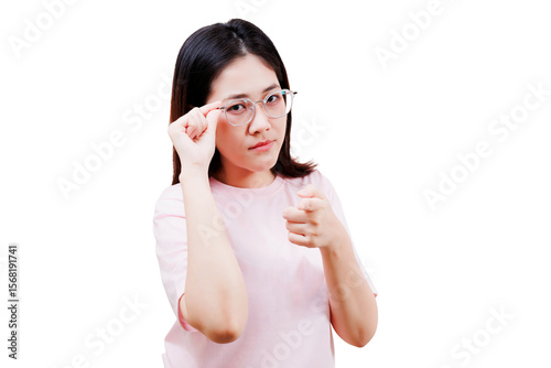 Asian young beautiful woman wearing glasses points forward with a confident and assertive expression, dressed in a light pink shirt.