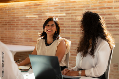 A young woman laughs during a meeting in the office in the office