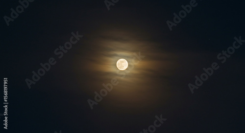 The radiant full moon illuminates the deep nocturnal expanse with its captivating and ethereal halo.
